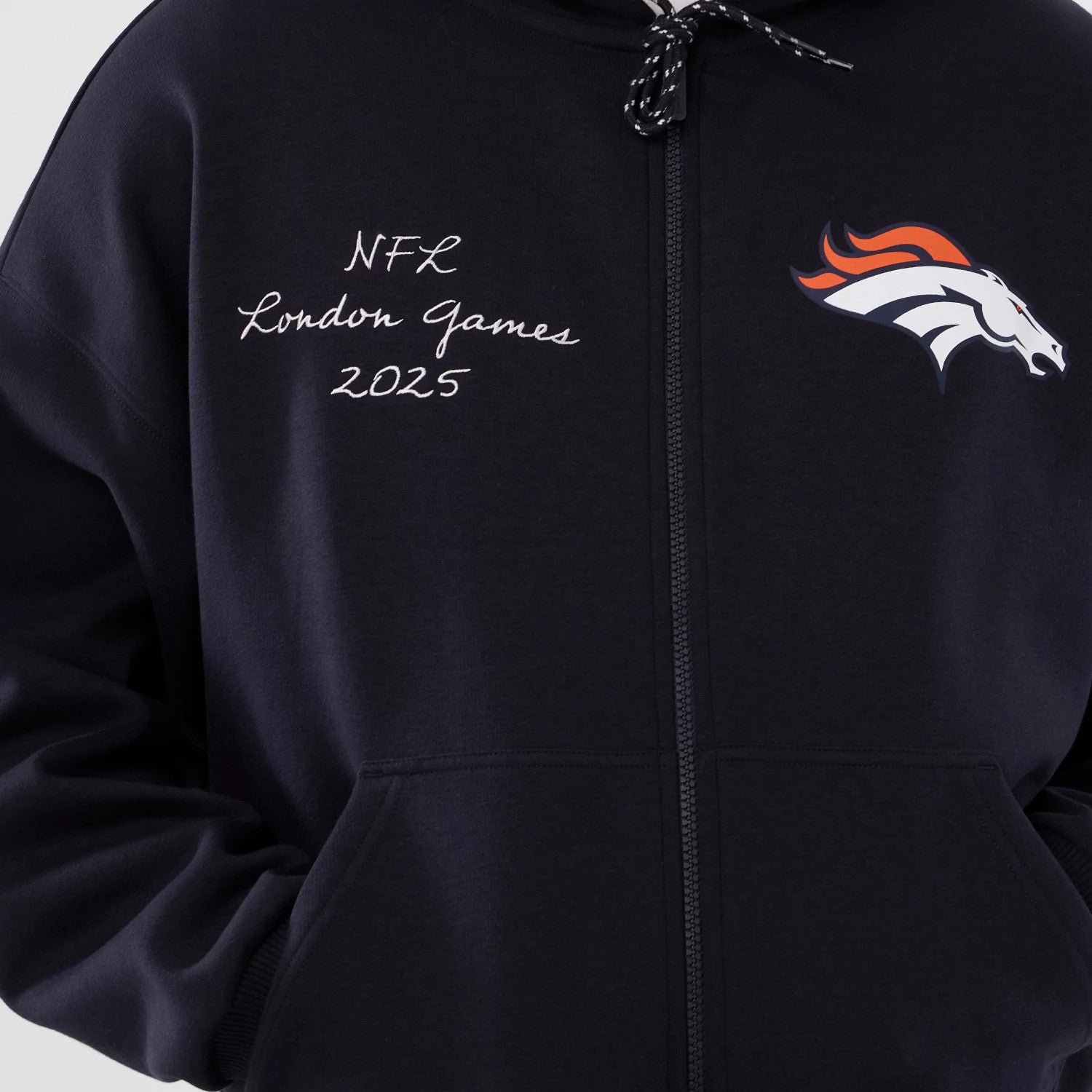 The Male model is wearing Denver Broncos NFL International Series Games 2025 Navy Premium Pullover Hoodie 3