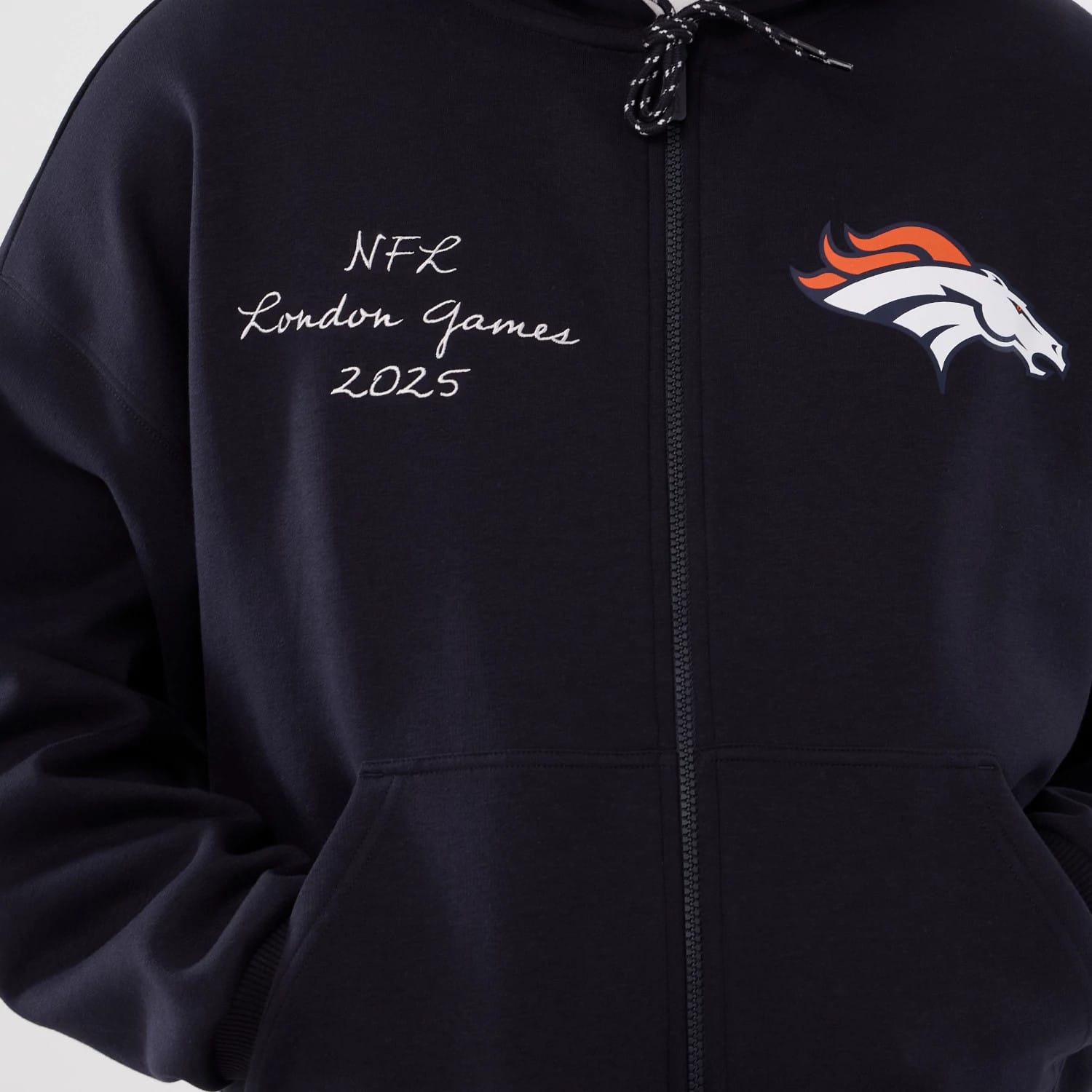 The Male model is wearing Denver Broncos NFL International Series Games 2025 Navy Premium Pullover Hoodie 3