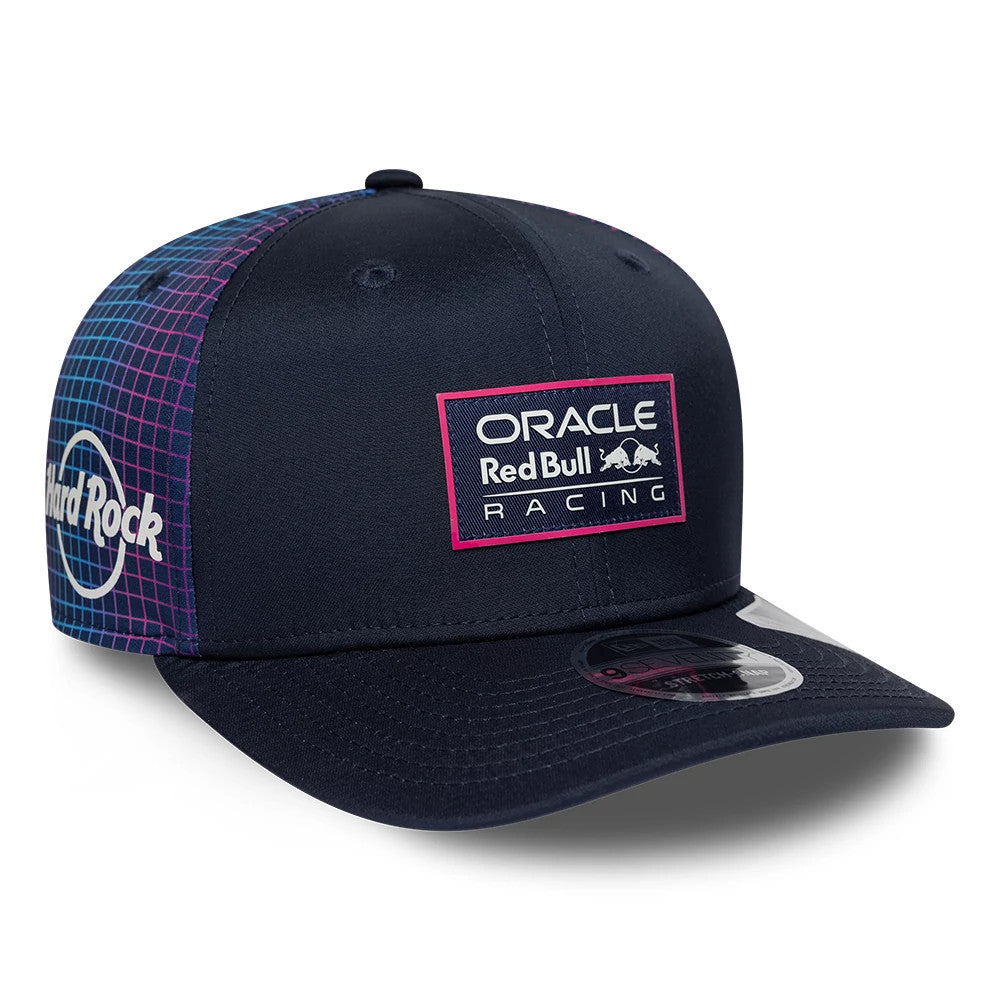 Red Bull Racing Miami Race Special Navy New Era 9SEVENTY Stretch Snap Adjustable Cap, three-quarter view showing a pink-outlined Red Bull Racing patch on the front panel, Hard Rock logo on the side, curved visor and 9SEVENTY size sticker.