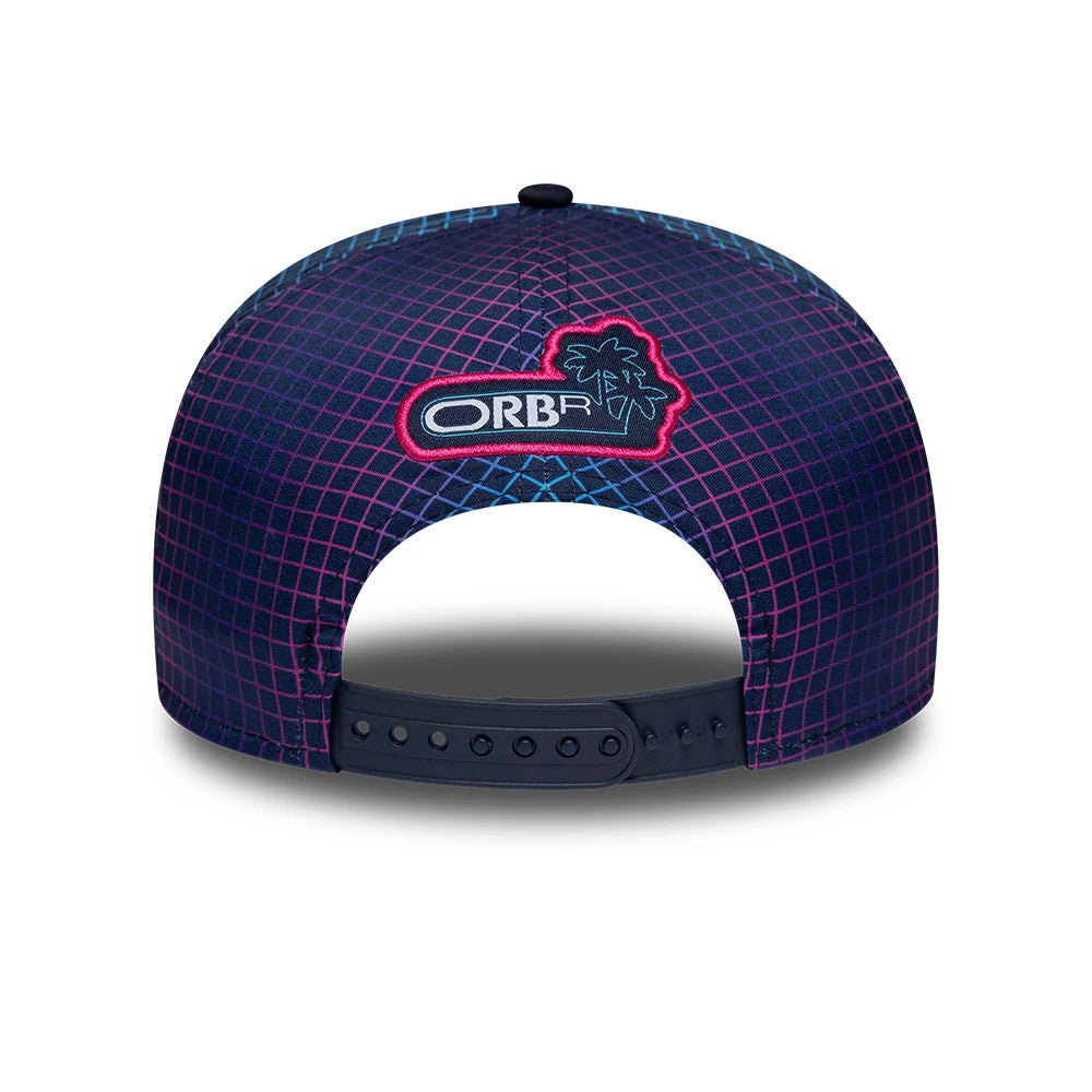 Red Bull Racing Miami Race Special Navy New Era 9SEVENTY Stretch Snap Adjustable Cap, rear view showing the embroidered ORBR logo with a palm tree icon, set against a navy and pink geometric grid pattern on the structured crown.