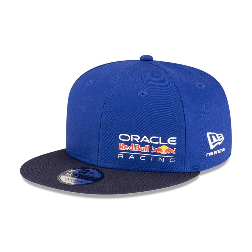 Red Bull Racing Essential Dark Blue New Era 9FIFTY Snapback Adjustable Cap, front view showing the white and red embroidered team logo on the front panel, dark blue flat visor with a 9FIFTY size sticker, and New Era flag logo on the left side.