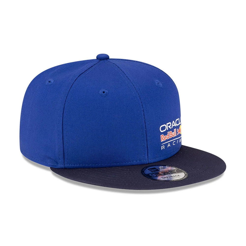 Red Bull Racing Essential Dark Blue New Era 9FIFTY Snapback Adjustable Cap, three-quarter view with raised Oracle and Red Bull Racing embroidery on the front panel, a flat dark blue visor, and a 9FIFTY size sticker on the top.