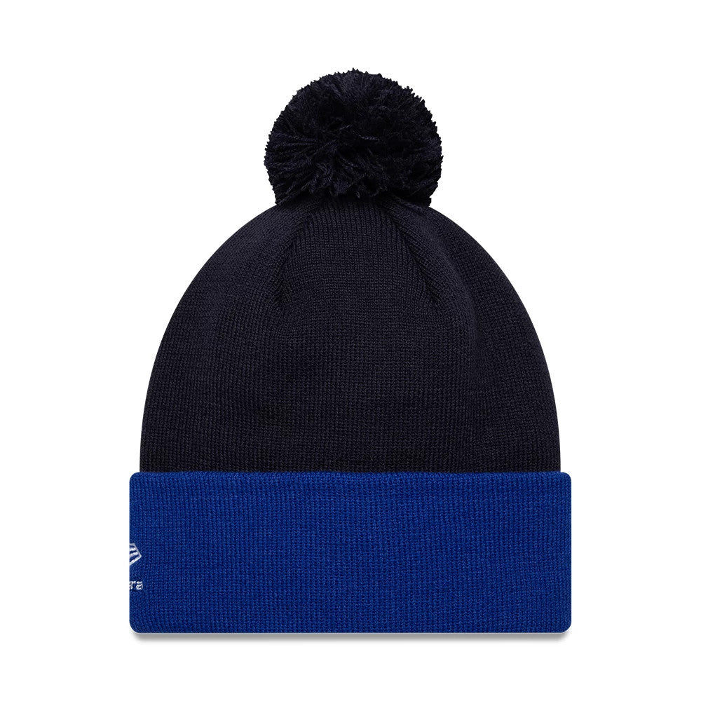 New Era Red Bull Racing Essential Dark Blue Bobble Knit Beanie Hat, front view showing a dark blue knitted design with a matching bobble on top and a contrasting blue fold-over cuff with the New Era flag logo embroidered on the left side.