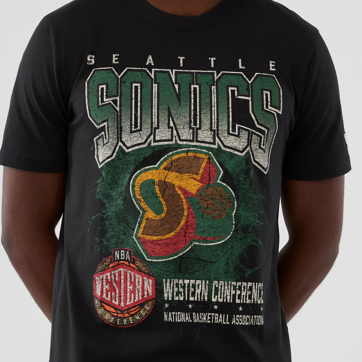 New Era Seattle Supersonics NBA Hardwood Classic Black T-Shirt, front view showing a large distressed SONICS graphic in green and white across the chest, with a retro Supersonics logo and Western Conference emblem below, worn by a model.
