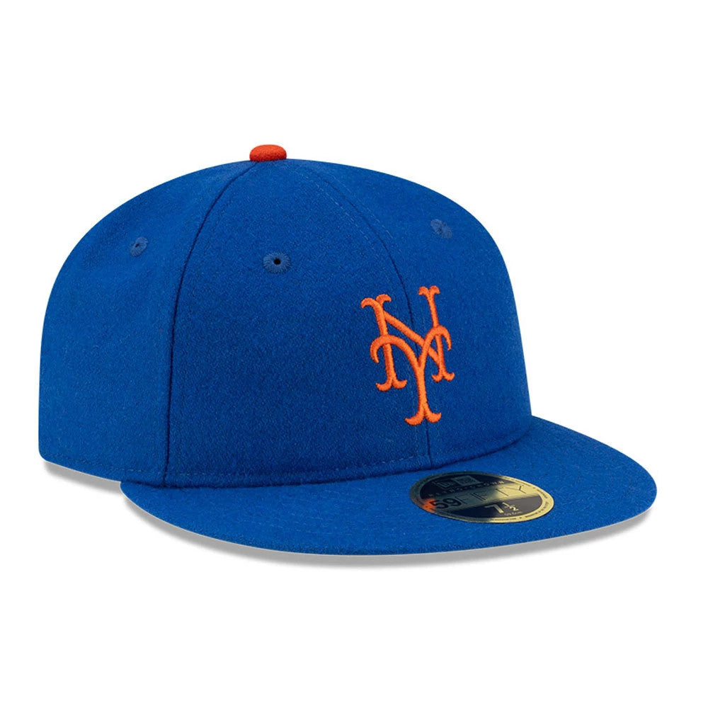 New York Mets FOG X MLB Blue Retro Crown New Era 59FIFTY Fitted Cap, three-quarter view showing the orange embroidered NY logo on the front panel, blue flat visor with a gold 59FIFTY size sticker, and red top button.