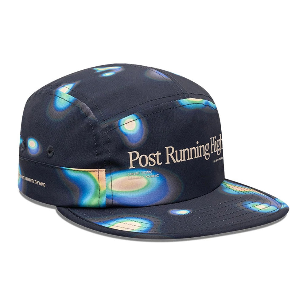 Hermanos Koumori x New Era Navy Camper Cap, three-quarter view with abstract multicoloured print pattern, features Post Running High text on the front panel and small script on the side, with a soft structured crown.
