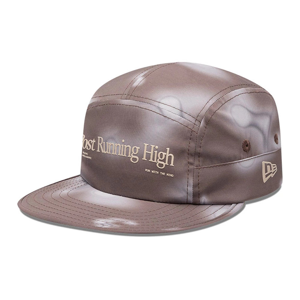 Hermanos Koumori x New Era Dark Brown Camper Cap, three-quarter view showing the cream Post Running High embroidery on the front panel, with a flat dark brown visor and New Era logo on the left side.