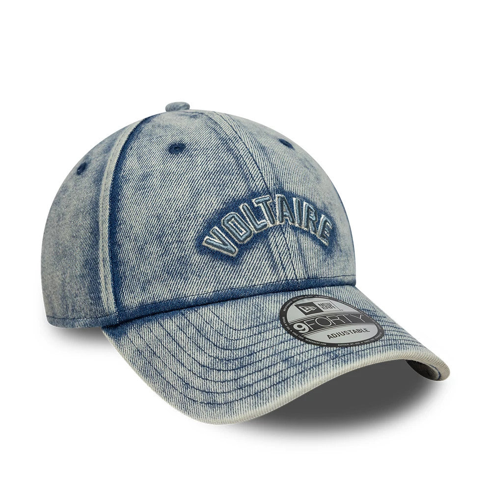 New Era X Zadig & Voltaire Pastel Blue 9FORTY Adjustable Cap, three-quarter view showing the raised embroidered Voltaire logo in dark blue on the denim-textured crown with matching top button and eyelets, featuring a 9FORTY size sticker on the visor.