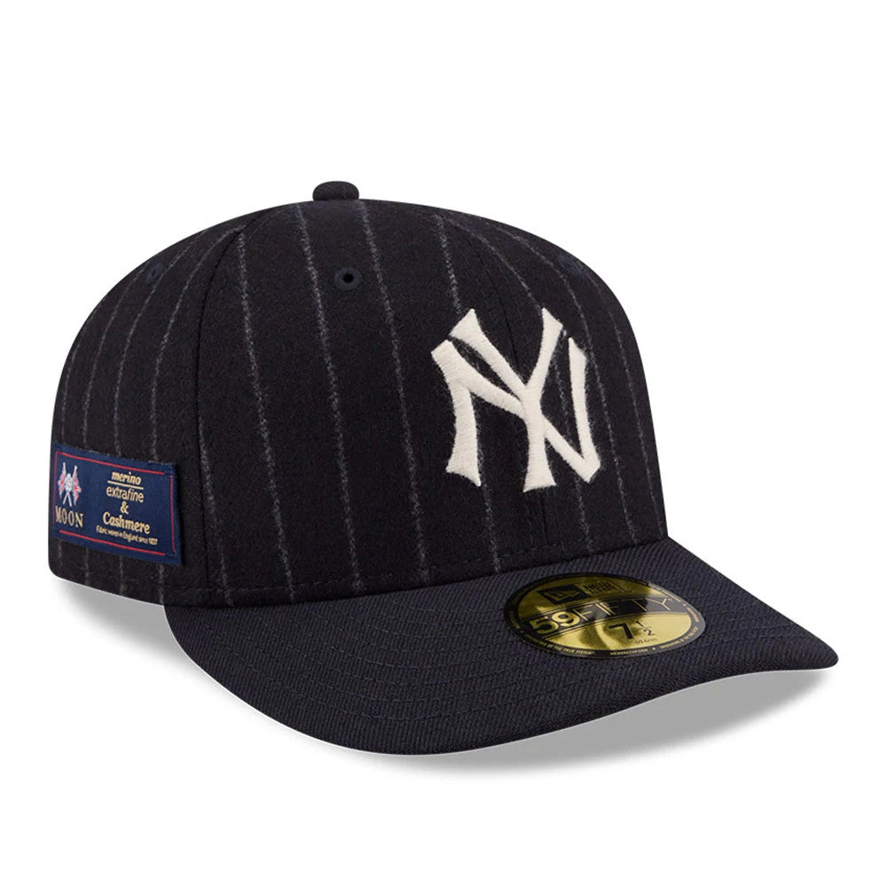 New York Yankees MLB X Moon Navy New Era 59FIFTY Fitted Cap, three-quarter view showing the white embroidered NY logo on the pinstriped navy front panels, a gold 59FIFTY size sticker on the flat visor, and a Moon fabric label on the left side.