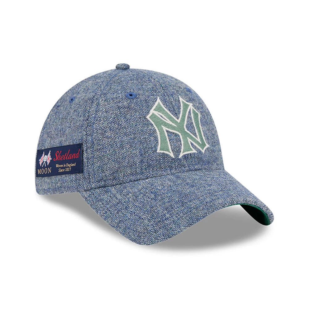 New York Yankees MLB X Moon Blue New Era 9TWENTY Adjustable Cap, three-quarter view showing the white and green embroidered NY logo on the front panel, with a green undervisor and a Moon Shetland woven label on the side.