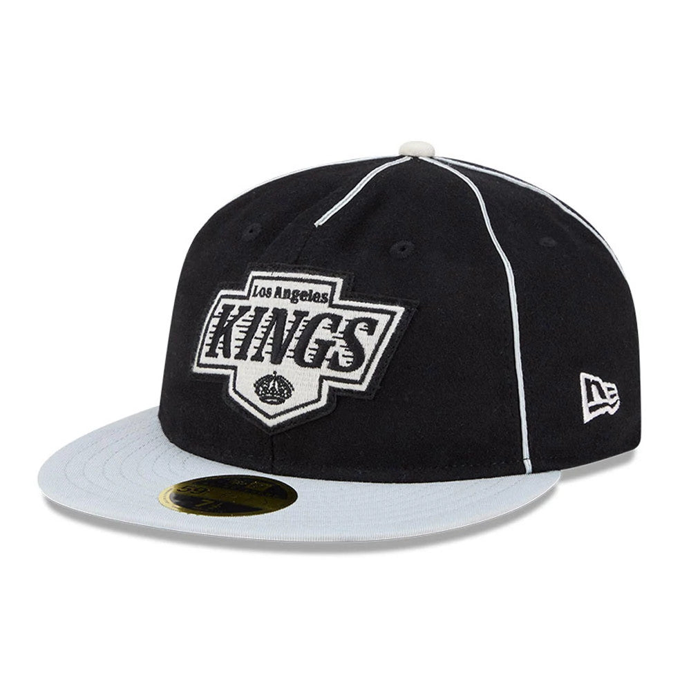 LA Kings NHL Felt Logo Black Retro Crown New Era 59FIFTY Fitted Cap, three-quarter view showing the white embroidered Los Angeles Kings logo on the front panel, grey flat visor with gold 59FIFTY size sticker, and New Era flag logo on the left side.
