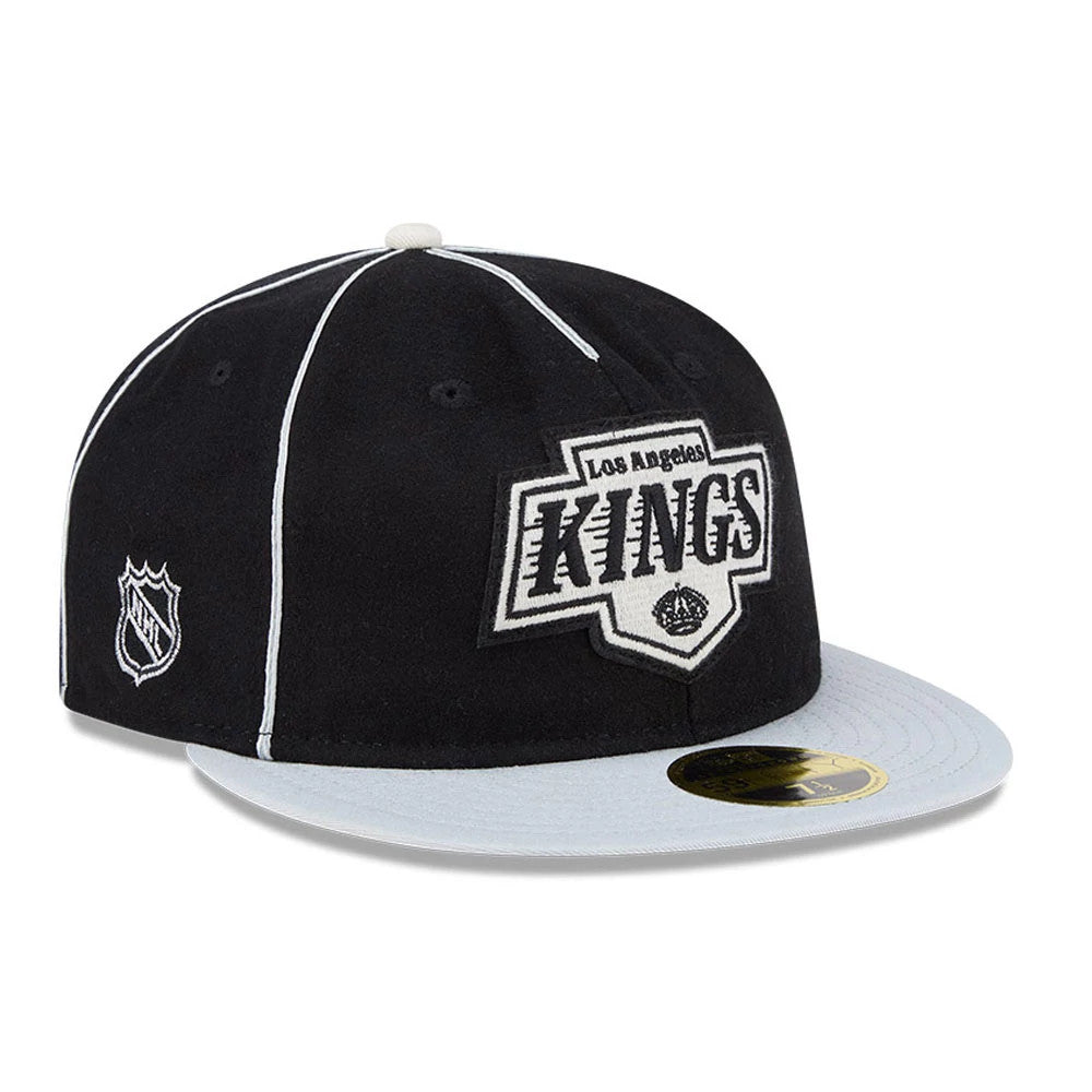 LA Kings NHL Felt Logo Black Retro Crown New Era 59FIFTY Fitted Cap, three-quarter view showing the large felt LA Kings logo in black and white embroidered on the front panel, grey visor with gold 59FIFTY size sticker.