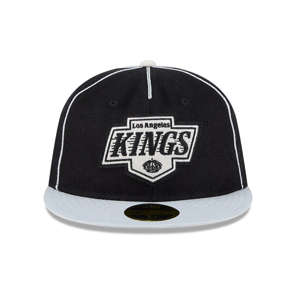 LA Kings NHL Felt Logo Black Retro Crown New Era 59FIFTY Fitted Cap, front view showing the large raised black and white embroidered logo on the front panel, with a contrasting light grey flat visor and a gold 59FIFTY size sticker underneath.