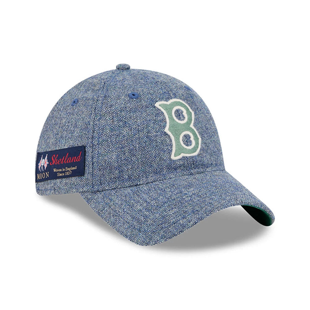 Boston Red Sox MLB X Moon Blue New Era 9TWENTY Adjustable Cap, three-quarter view showing the white and green embroidered B logo on the front panel, a curved blue visor, and the Shetland Moon patch on the side.
