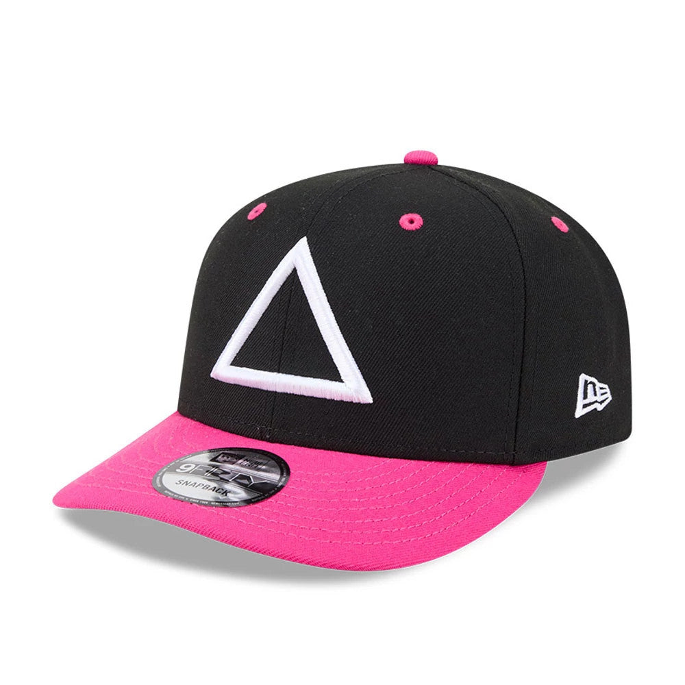 Netflix Squid Game Armed Guard Black New Era 9FIFTY Snapback Adjustable Cap, three-quarter view showing the white triangle logo embroidered on the front panel, a bright pink visor, and the New Era flag logo on the left side.