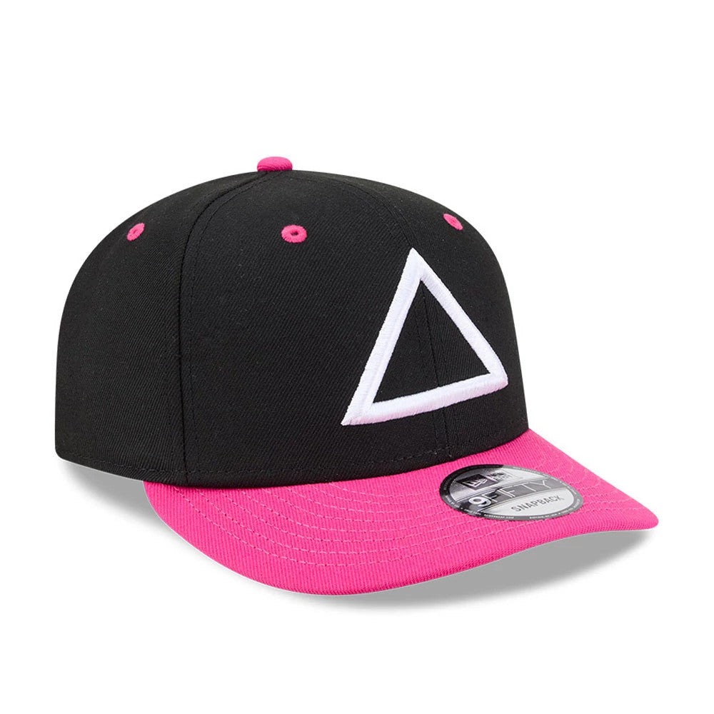 Netflix Squid Game Armed Guard Black New Era 9FIFTY Snapback Adjustable Cap, three-quarter view showing the white embroidered triangle logo on the front black panel, bright pink visor and top button, and 9FIFTY size sticker on the visor.