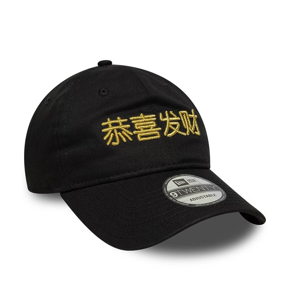 New Era Lunar New Year Black New Era 9TWENTY Adjustable Cap, three-quarter view showing gold embroidered Chinese characters on the front panels, a slightly curved black visor with a 9TWENTY size sticker, and a top button in the same colour.