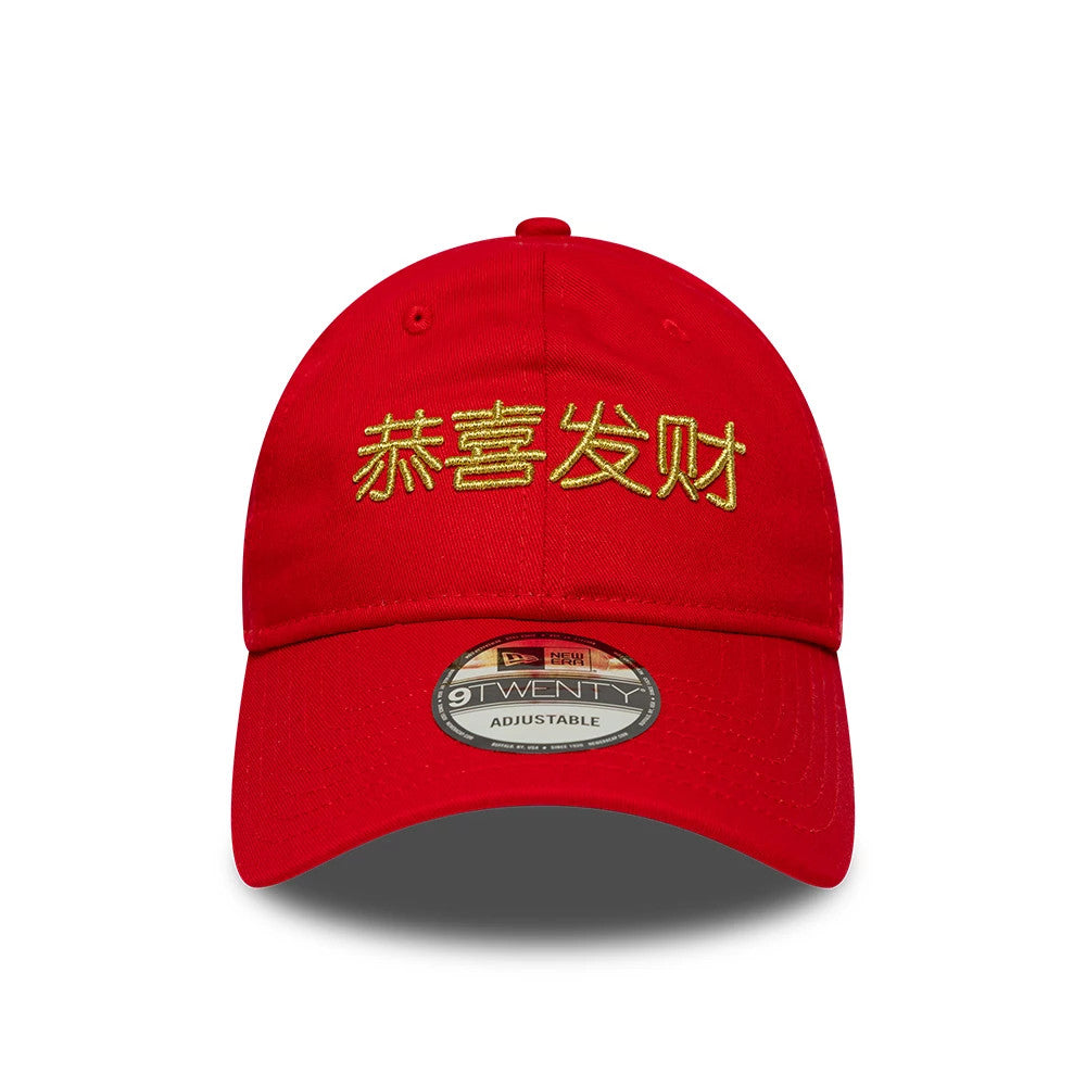 New Era Lunar New Year Red 9TWENTY Adjustable Cap, front view showing gold embroidered Chinese characters on the red crown, a curved visor, and a 9TWENTY size sticker centrally placed on the visor.