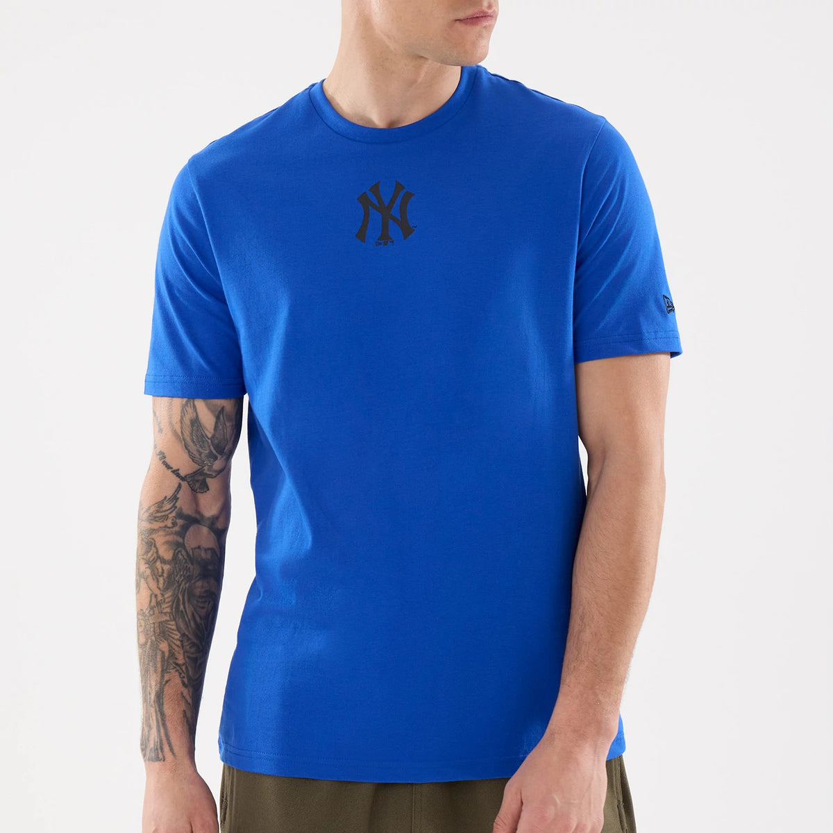 New Era New York Yankees MLB Blue T-Shirt, front view on a model, highlighting the black printed Yankees logo at the centre of the chest, a simple crew neck collar, and a small embroidered New Era flag on the left sleeve.