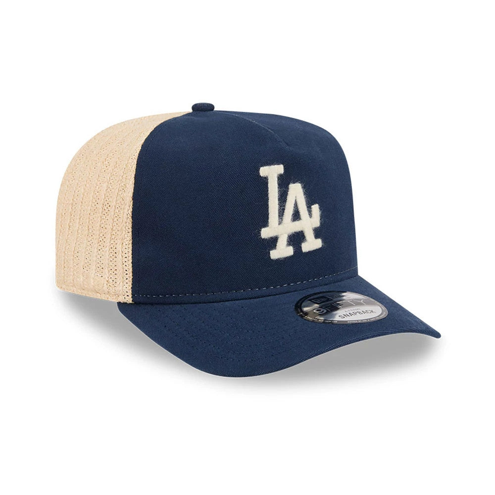 LA Dodgers MLB Grained Dark Blue New Era 9FIFTY A-Frame Snapback Adjustable Cap, three-quarter view showing the white raised embroidered LA logo on the dark blue front panel, contrasting cream mesh side panels, and a 9FIFTY size sticker on the visor.