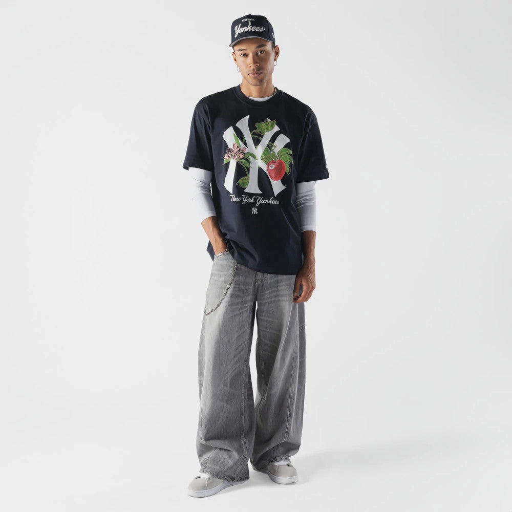 New Era New York Yankees MLB Life Graphic Navy T-Shirt, front view on-model paired with grey wide-leg jeans and a cap, featuring a large Yankees logo with floral imagery across the front and New York Yankees lettering below.