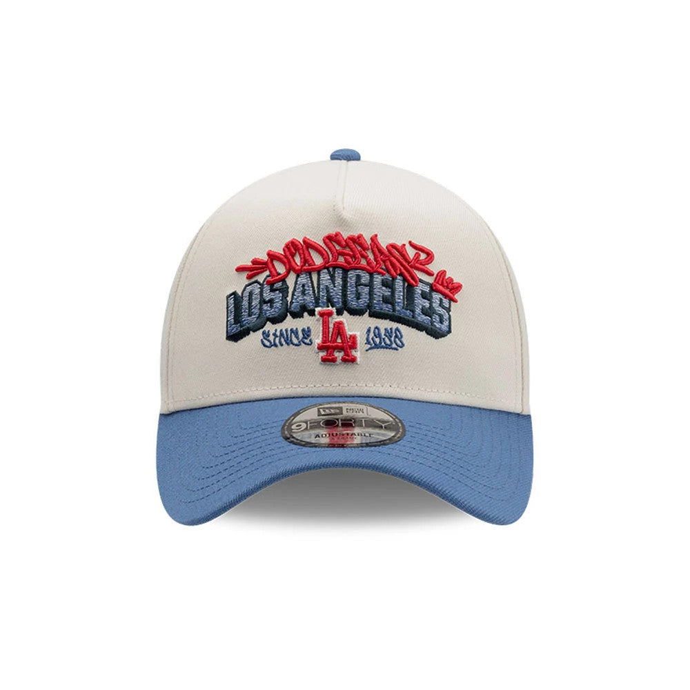 LA Dodgers MLB Tagged Light Beige New Era 9FORTY A-Frame Cap, front view showing red and blue embroidered graffiti-style Dodgers and Los Angeles graphics on the crown, an LA logo beneath, light blue curved visor, and 9FORTY size sticker on the visor.
