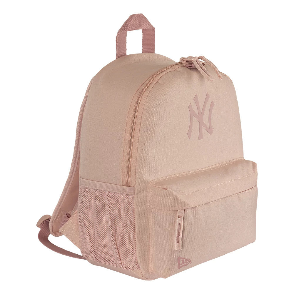 New Era New York Yankees MLB Mini Backpack Pastel Pink Stadium Backpack, three-quarter view showing a large printed Yankees logo on the front, a zip pocket below, mesh side pocket, and a raised New Era logo at the bottom right corner.