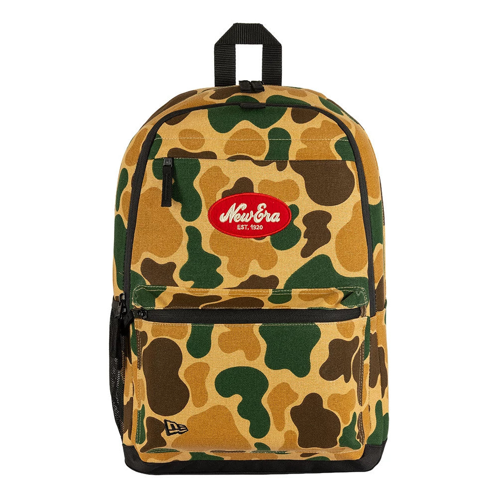New Era Camo Light Beige Delaware Backpack, front view showing the camo pattern in shades of light beige, green, and brown, with a red embroidered New Era logo centred near the top, and a small embroidered logo at the bottom corner.
