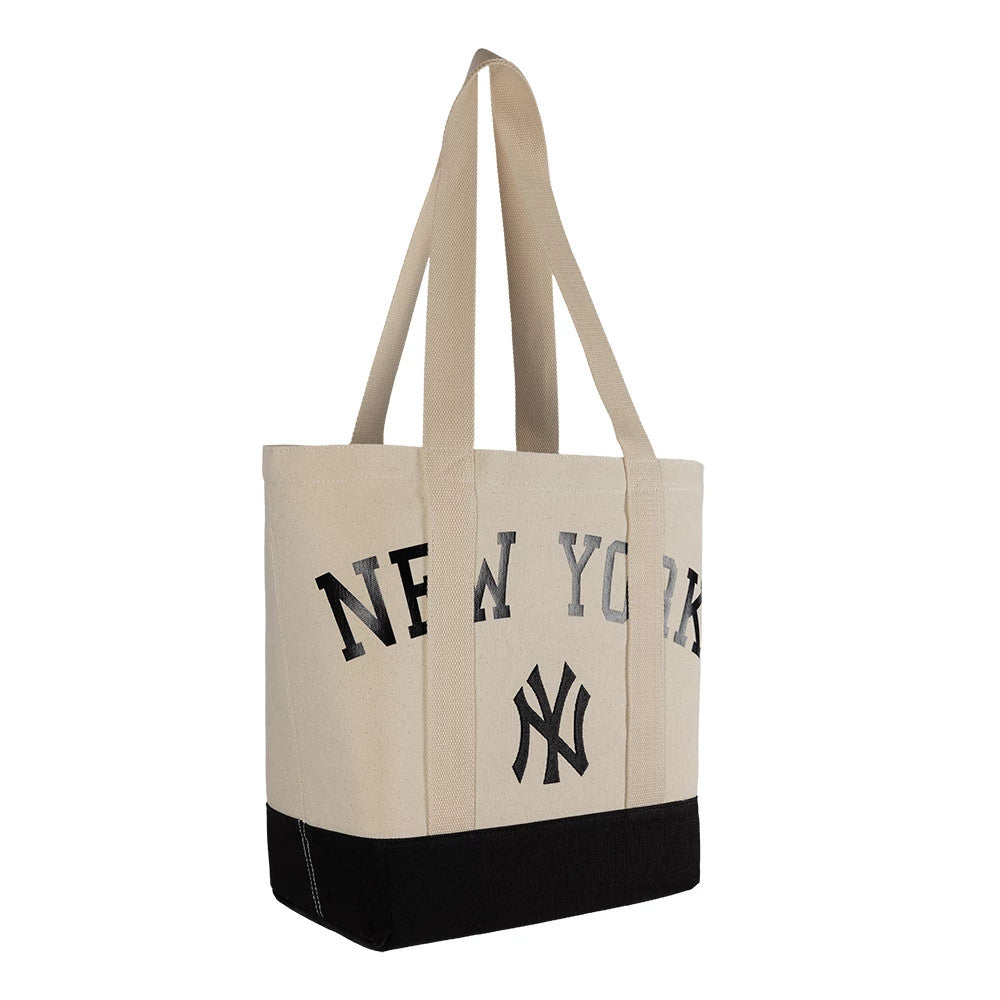 New Era New York Yankees MLB Script Light Beige Tote Bag, three-quarter view showcasing the large black embroidered New York Yankees lettering on the front, double shoulder straps, and a contrasting black base adding a touch to the light beige body.