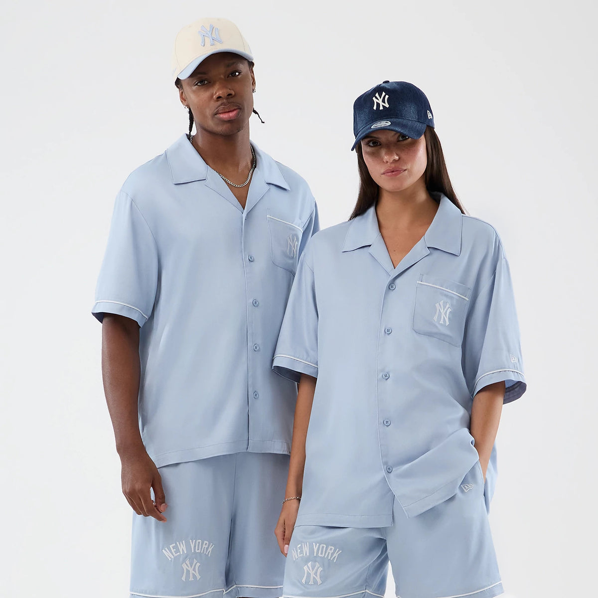 New Era New York Yankees MLB Graphic Revere Pastel Blue Short Sleeve Shirt, front view on a model with matching shorts, featuring white embroidered NY logos on the chest pocket and shorts, white piping details on the sleeves and pockets.
