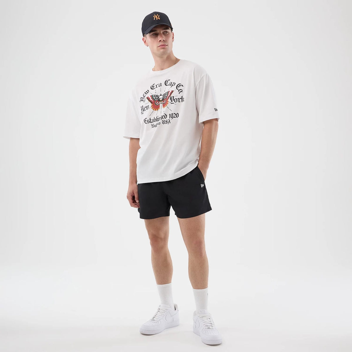 The model is wearing this New Era Death Moth Graphic Oversized T-Shirt in white. 8