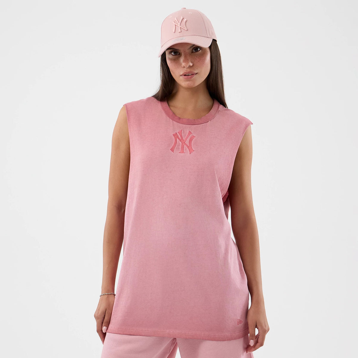 New Era New York Yankees MLB Washed Logo Pastel Pink Vest, front view on a model with a matching pastel pink cap, featuring a large pink embroidered Yankees logo on the chest, sleeveless design, and a relaxed fit.