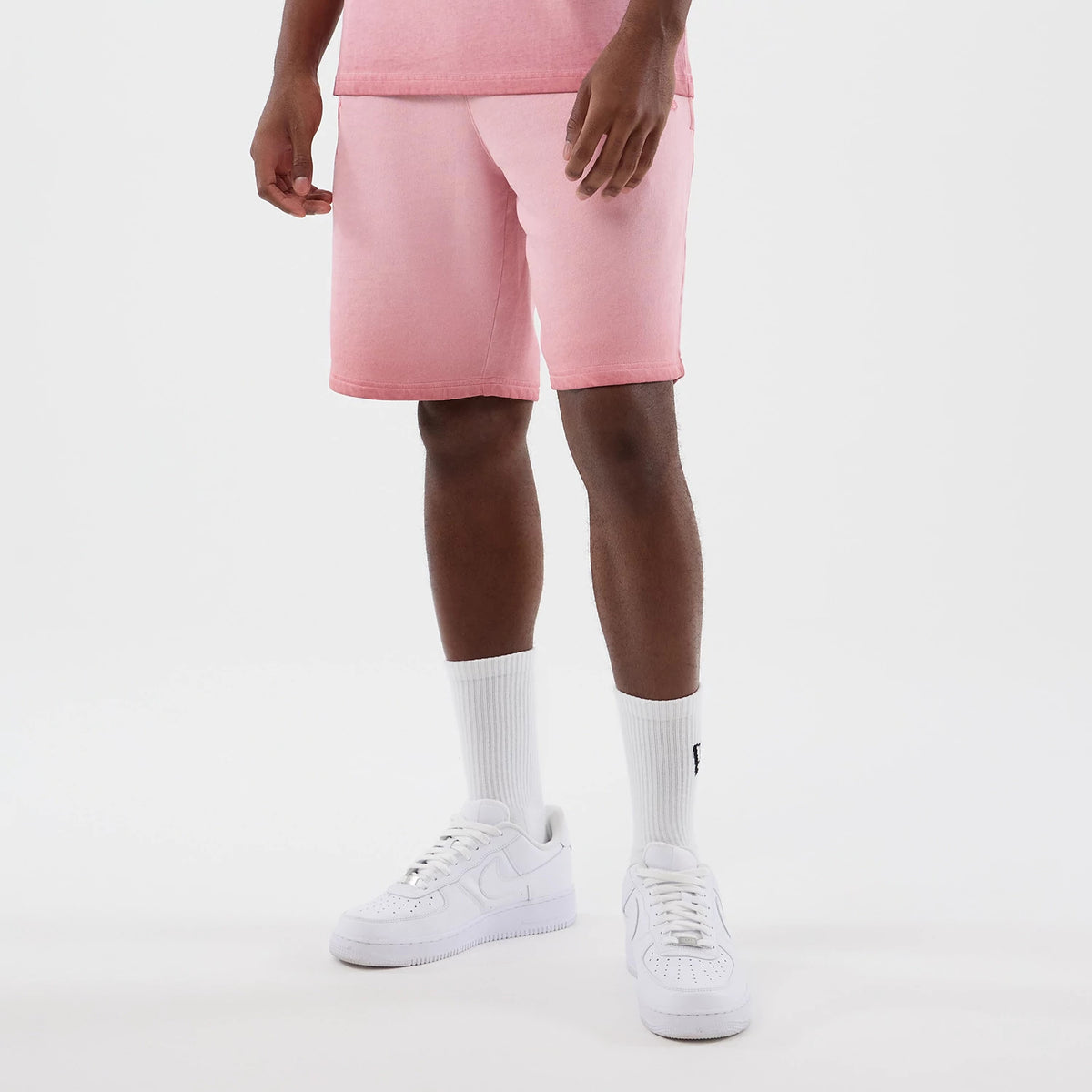 New Era New York Yankees MLB Washed Logo Pastel Pink Shorts, front view on a model showing the soft pastel pink hue reaching above the knee, styled with white trainers and socks, capturing a casual and relaxed look with clean lines.