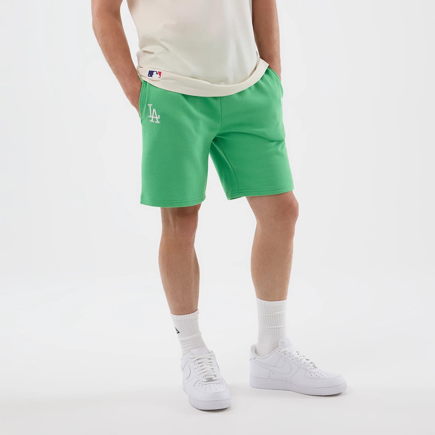 The model is wearing this MLB League Essential LA Dodgers Shorts in open green. 3