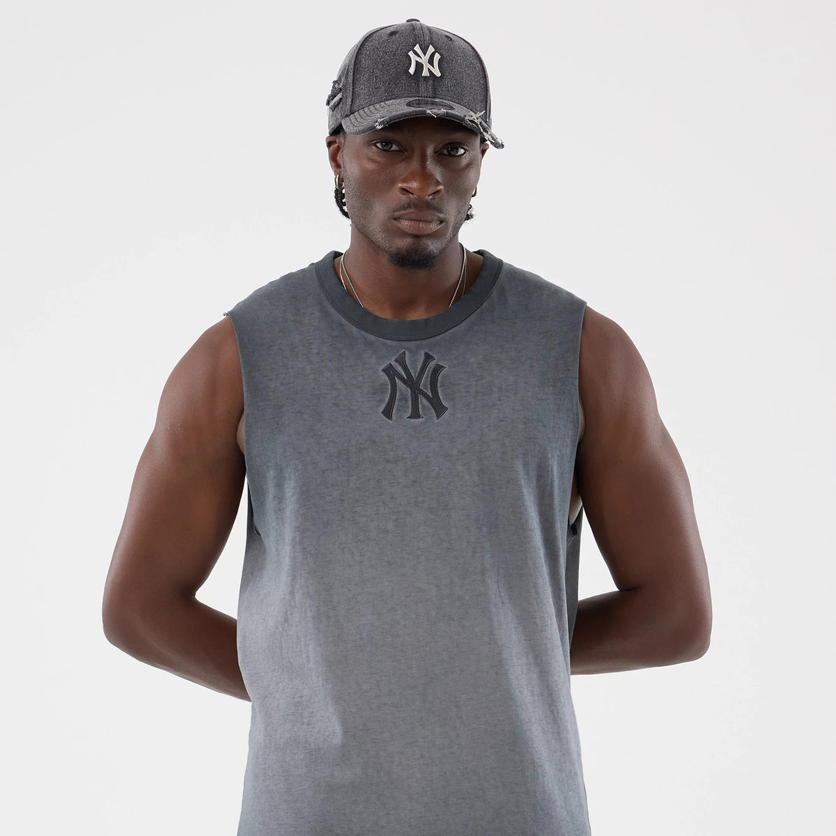 New Era New York Yankees MLB Washed Logo Black Vest, on-model front view with a sleeveless design and a prominent washed effect, featuring the Yankees logo in dark print across the chest, styled with a matching cap.