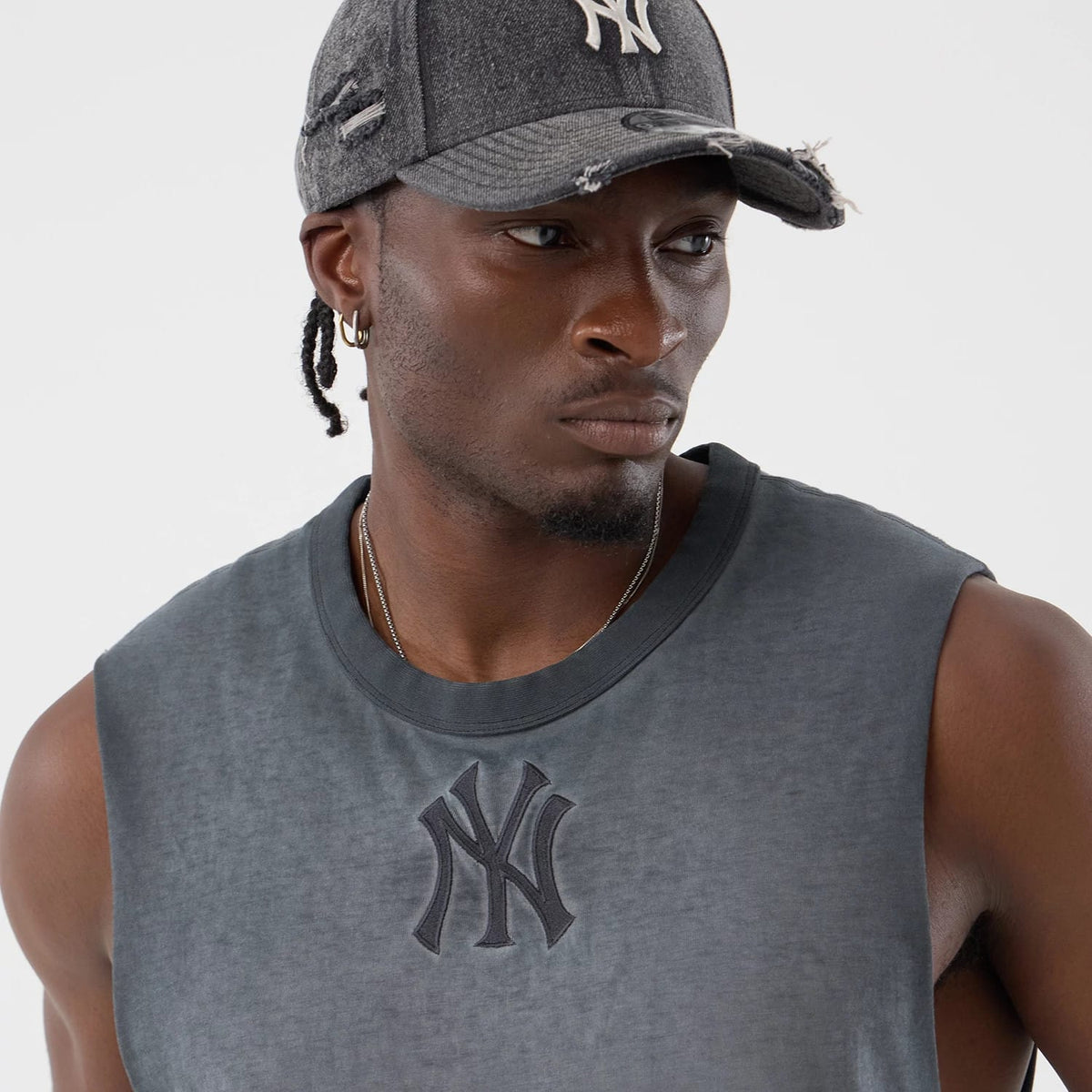 New Era New York Yankees MLB Washed Logo Black Vest, on-model front view with the New York Yankees logo in black raised embroidery on the chest, featuring a sleeveless design and a worn-in look that complements a distressed cap with a curved visor.