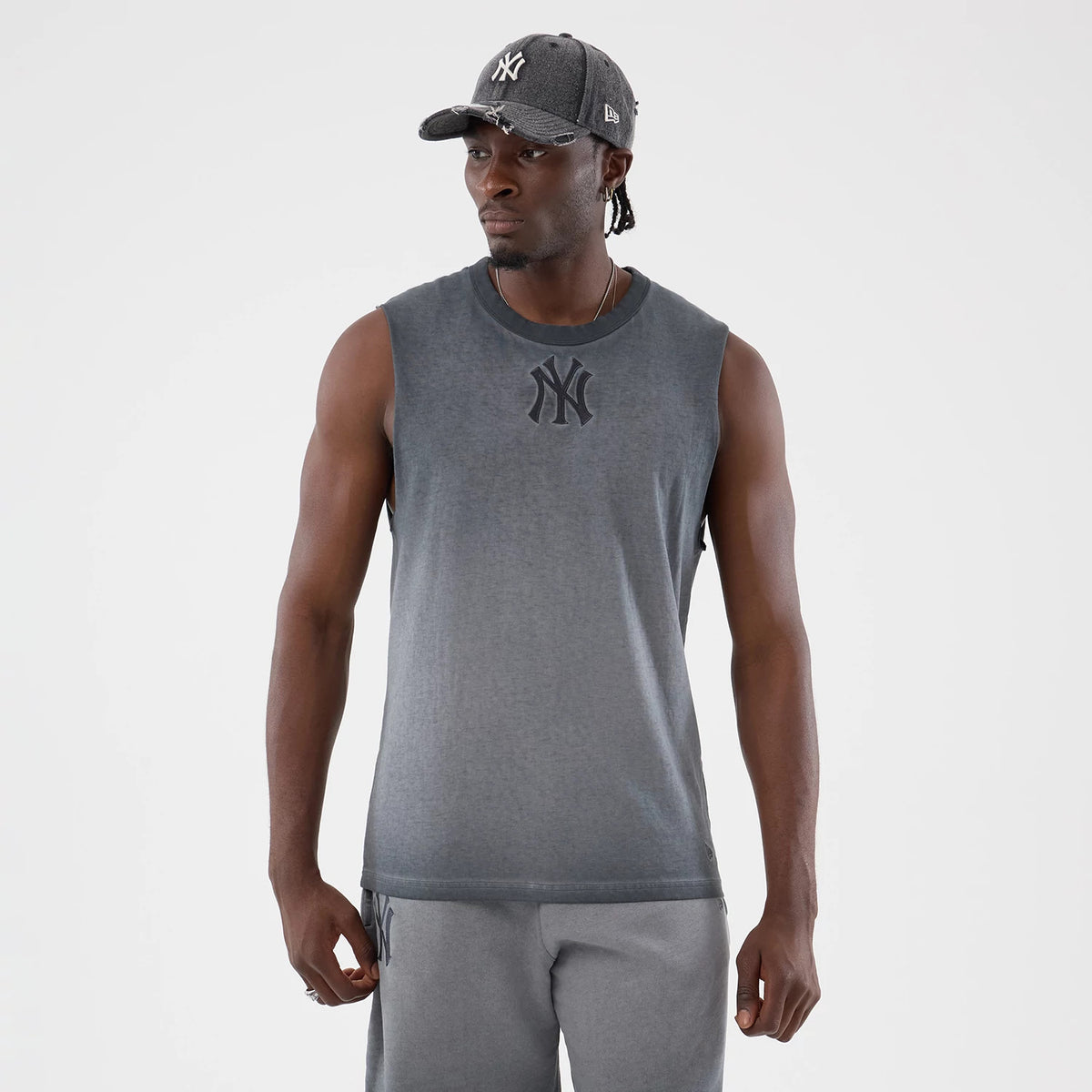 New Era New York Yankees MLB Washed Logo Black Vest, front view on a model with a matching grey cap, showing the large black embroidered Yankees logo on the chest, a ribbed collar, and gradient fabric detail.