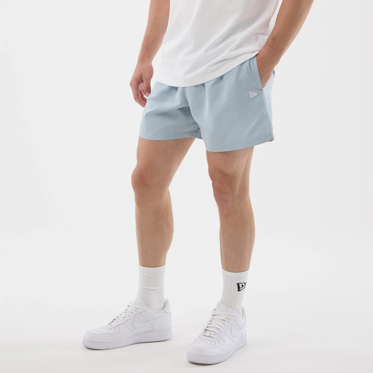 The model is wearing this New Era Swimming Shorts in pastel blue. 3