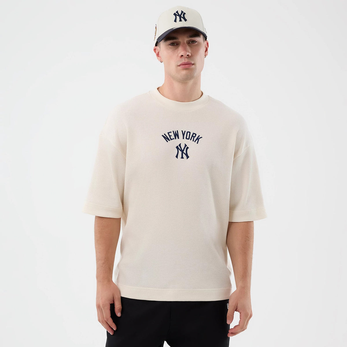 New Era New York Yankees MLB Waffle Open White T-Shirt, front view on-model showing the navy embroidered New York lettering and Yankees logo centred on the chest, with wide short sleeves and a ribbed neckline.