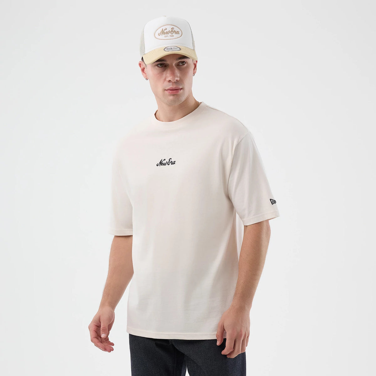 New Era Floral Graphic Open White Oversized T-Shirt, front view on-model displaying the relaxed white fit with a black embroidered New Era logo centred on the chest, a small embroidered logo on the left short sleeve, and paired with a matching cap.