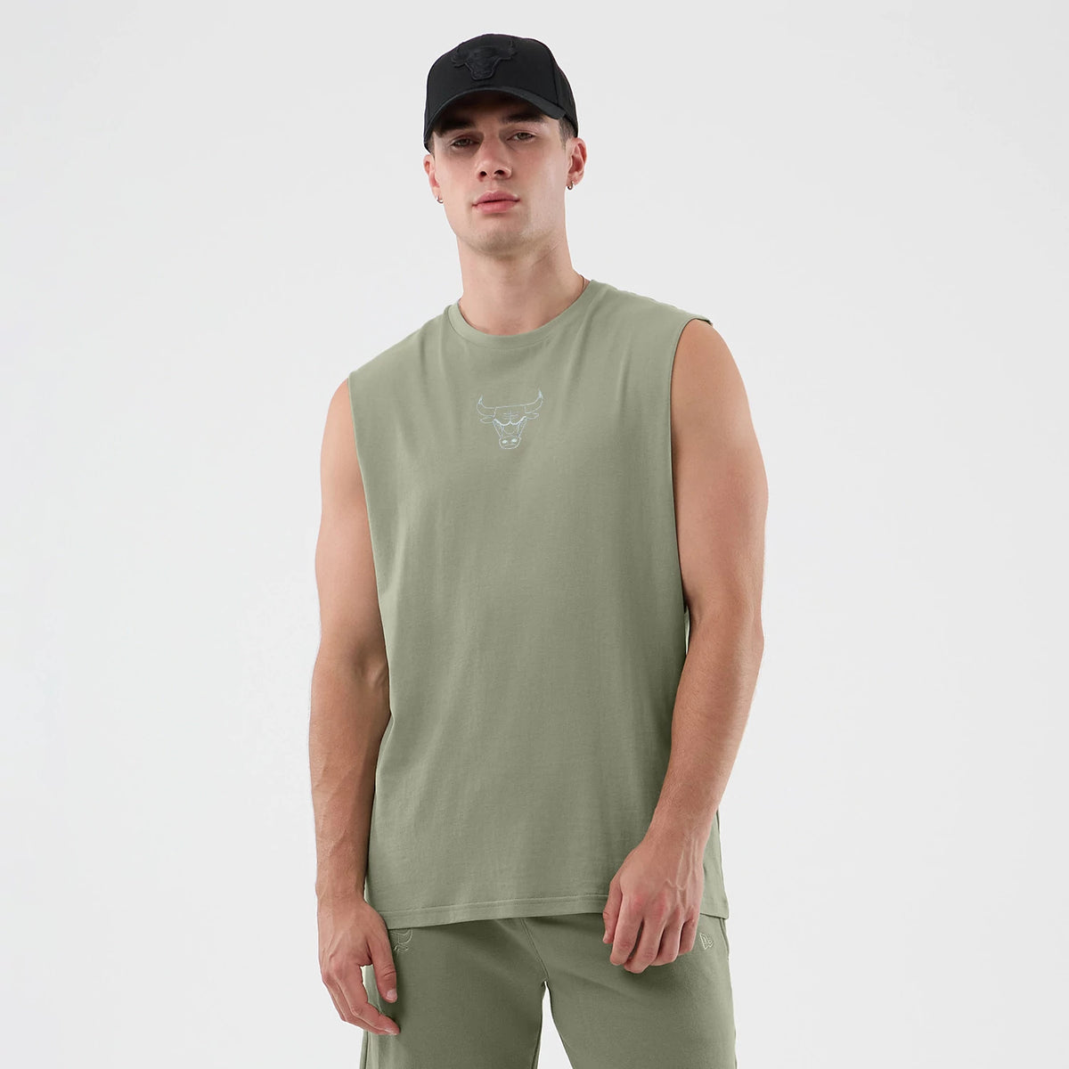 New Era Chicago Bulls NBA League Essential Pastel Green Vest, front view on a model wearing matching shorts and a black cap, featuring a small Bulls logo embroidered on the chest, sleeveless design, and a relaxed fit.