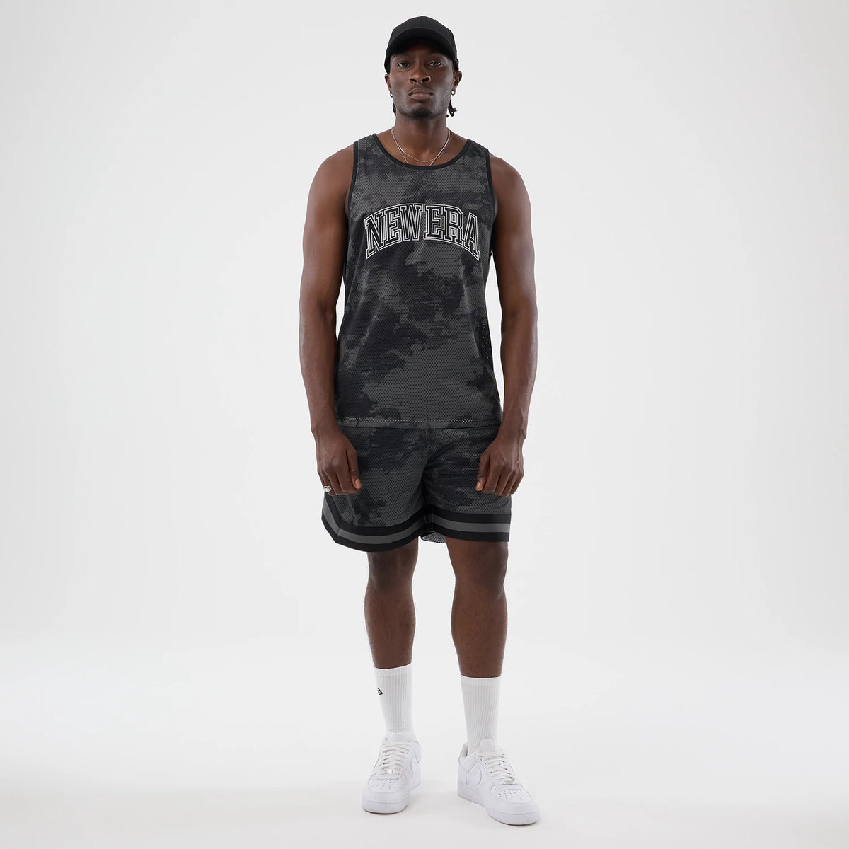 The model is wearing this New Era All Over Print Mesh Tank Top in black camo. 8