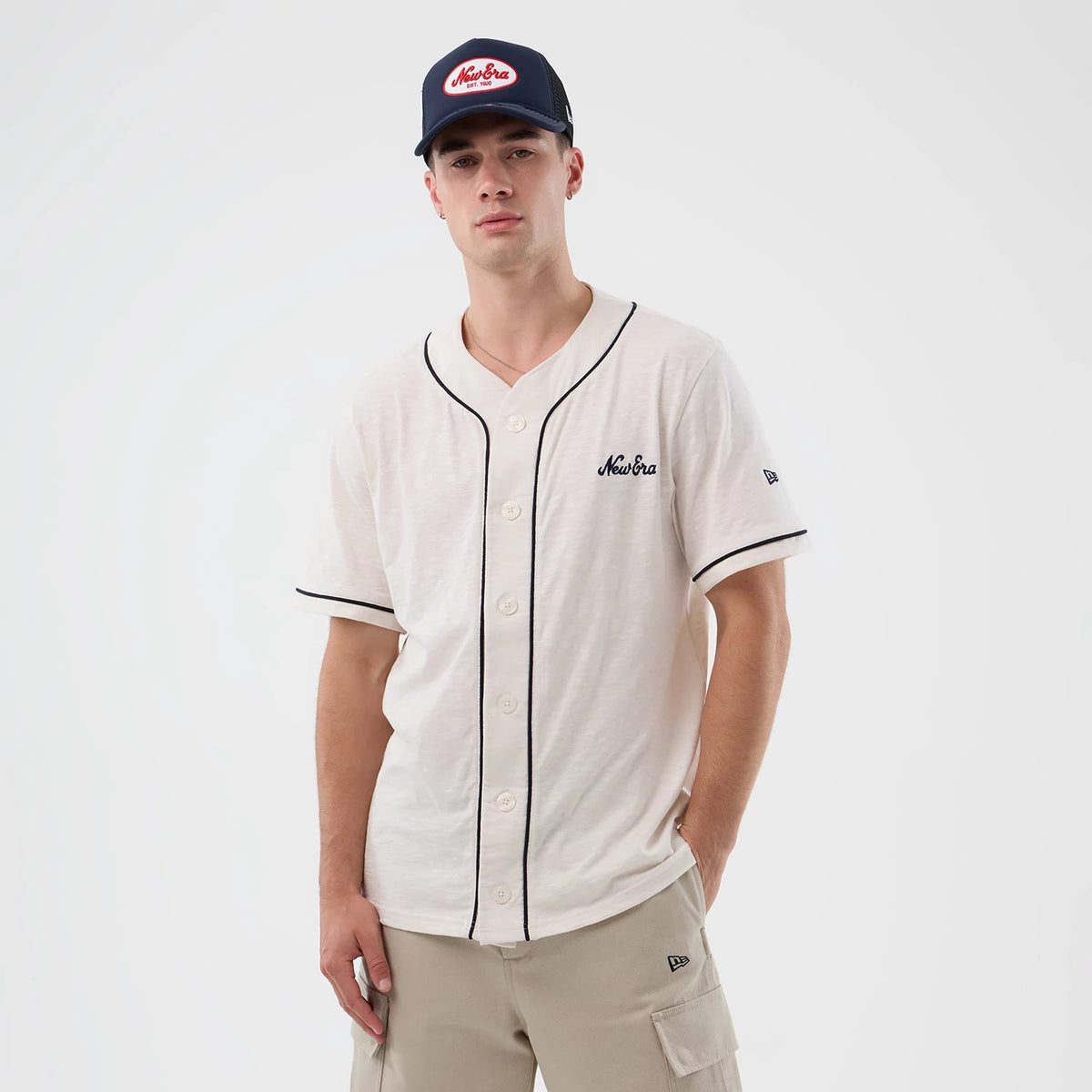 New Era Slub Open White Baseball Jersey, front view on a model with black piping detail along the button placket and sleeve edges, featuring an embroidered New Era script logo on the left chest and a logo on the left sleeve.