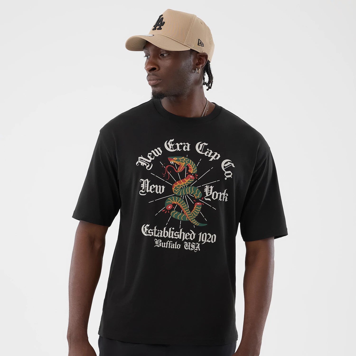 The model is wearing this New Era Serpent Graphic Oversized T-Shirt in black. 3