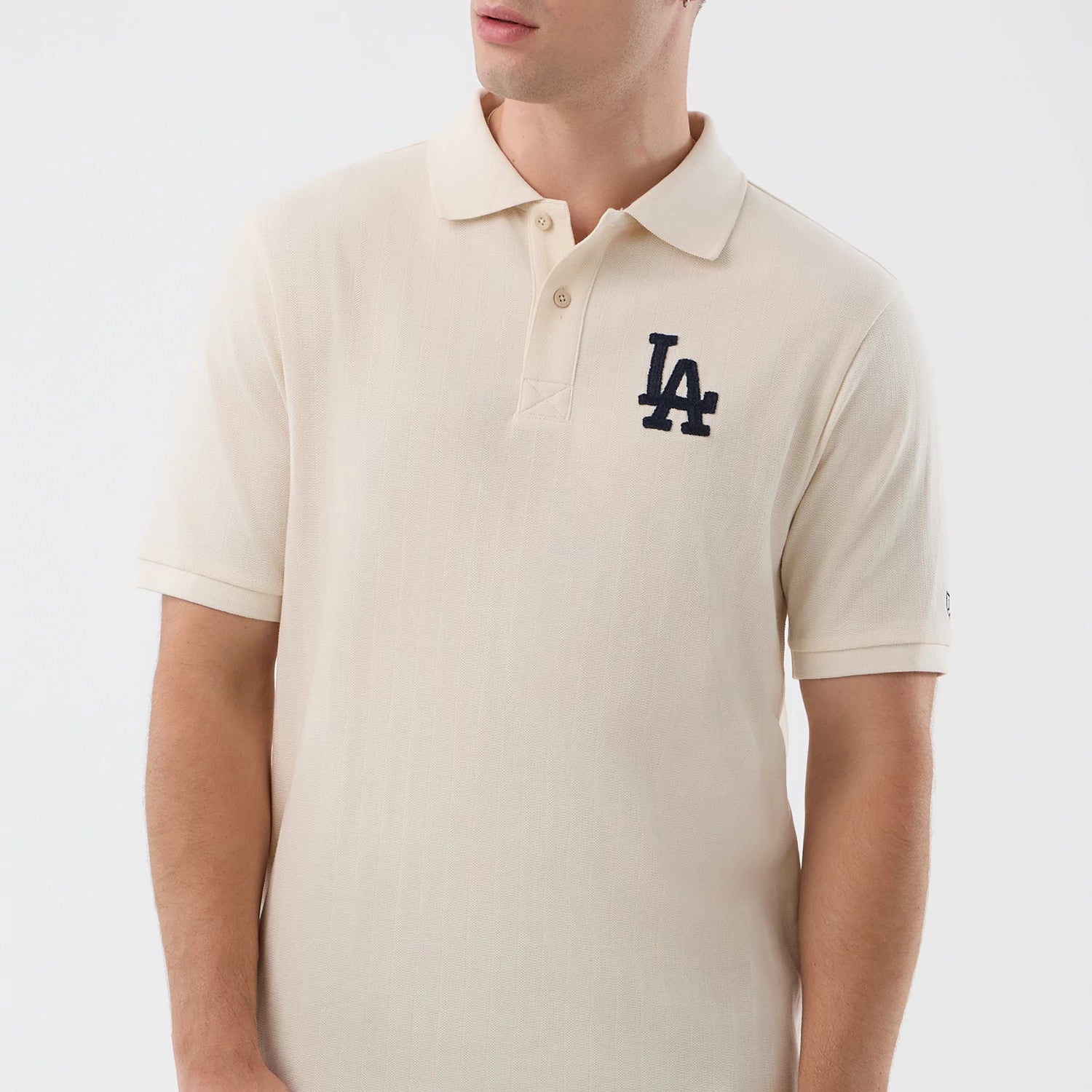 New Era LA Dodgers MLB Rib Open White Polo T-Shirt, front view showing the polo's classic collar and button placket, with an embroidered navy LA Dodgers logo on the left chest and rib on the light fabric, styled on a model.