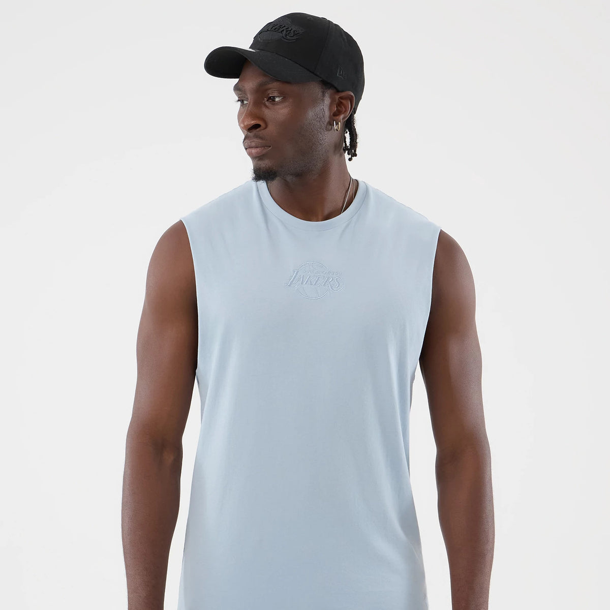 New Era LA Lakers NBA League Essential Pastel Blue Vest, front view on a model wearing a black cap, featuring a pastel blue colour, sleeveless design, and the LA Lakers logo embroidered in matching threads on the chest.