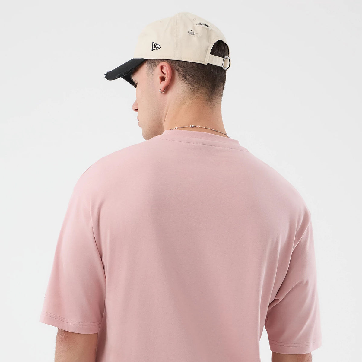 The model is wearing this New Era Beach Graphic Oversized T-Shirt in pastel pink. 8