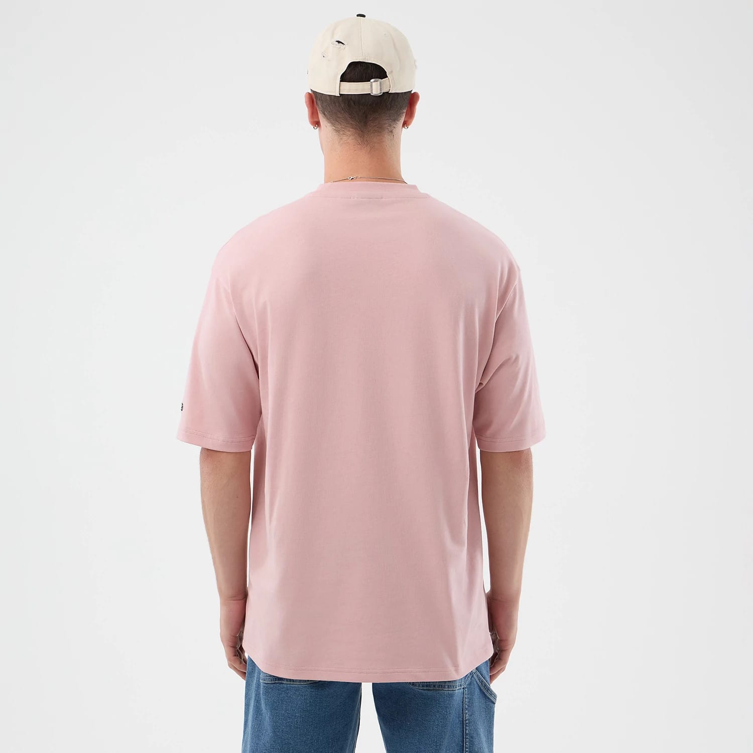 The model is wearing this New Era Beach Graphic Oversized T-Shirt in pastel pink. 2