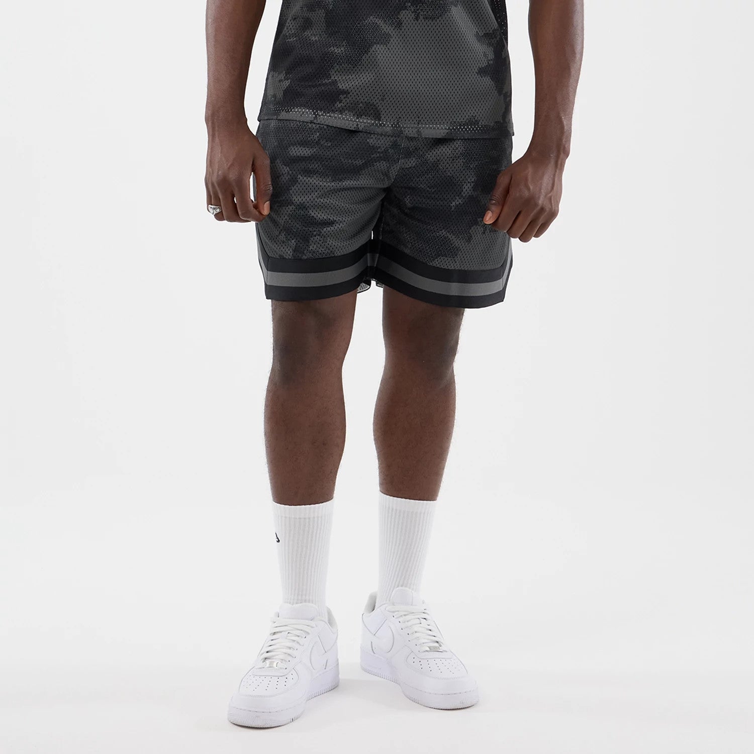 The model is wearing this New Era All Over Print Mesh Shorts in black camo. 1