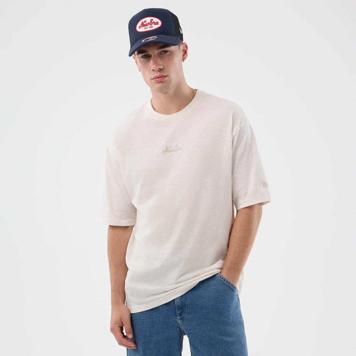 New Era Slub Open White Oversized T-Shirt, front view on a model wearing a navy cap, featuring a embroidered New Era logo on the chest, wide short sleeves, and a discrete embroidered logo on the left sleeve.